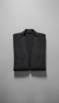 Knitwear cardigan in 'Urban Onyx'. The product sits centered on a plain 'Concrete Gray' background, while a subtle shadow...